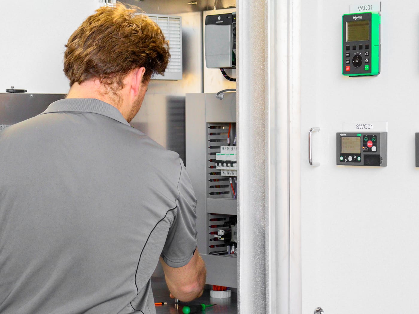 Technician fitting control and automation gear into a switchboard