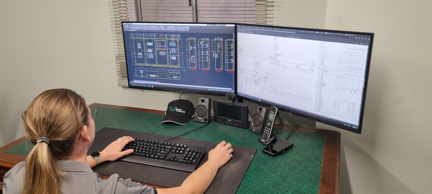 Electrical drafting on dual monitors showing switchboard schematics